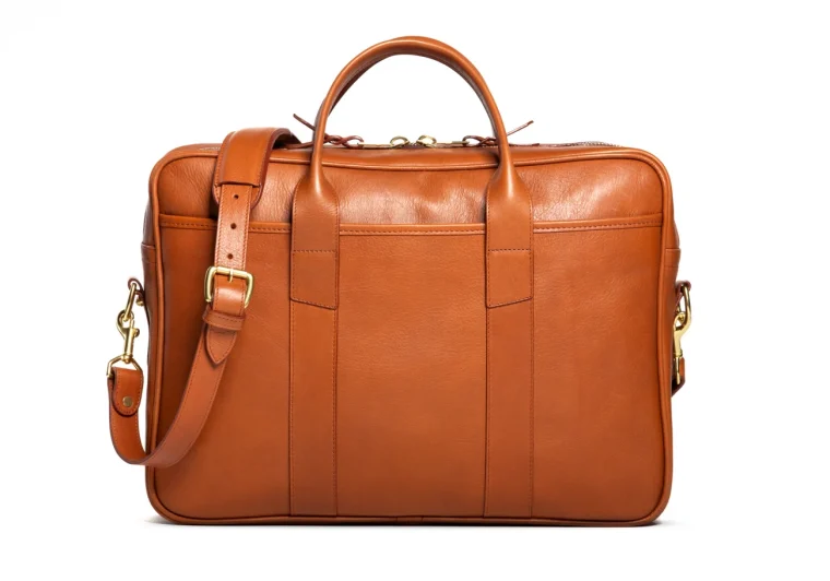 full-grain leather commuter bag in cognac color, standing on a desk